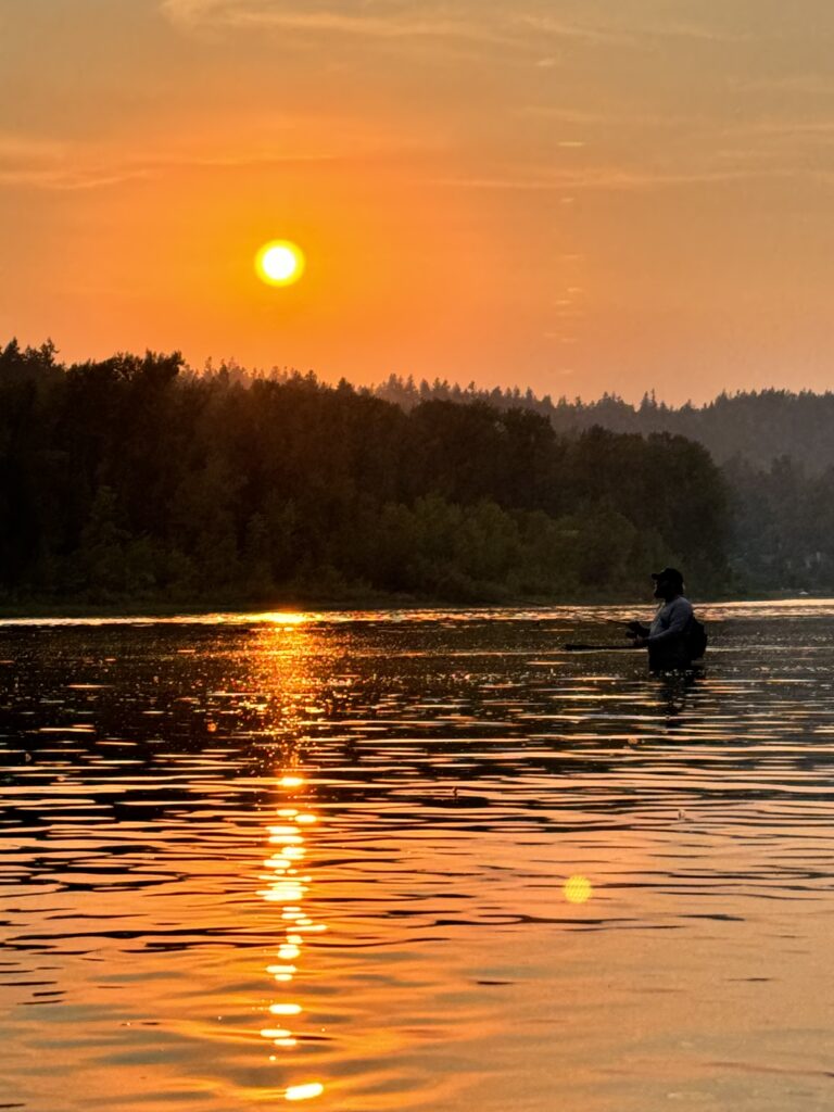 angler fishing for chinook salmon in river at sunrise